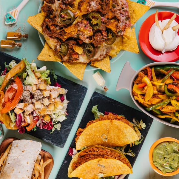 A vibrant spread of La Bamba's Mexican dishes, including nachos, tacos, fajitas, salad, and a burrito.