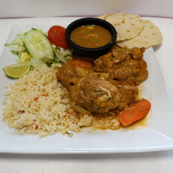 La Bamba's Mexican chicken dish with rice, salad, lime, tortillas, and a side of sauce.